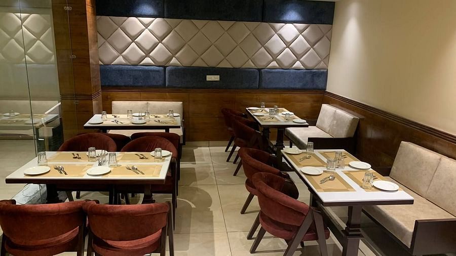 The Mastiff Hotel in Dalhousie showcases stylish interior design with tables arranged in a Tangelo theme as seen from a side perspective -  Mastiff Hotel, Dalhousie
