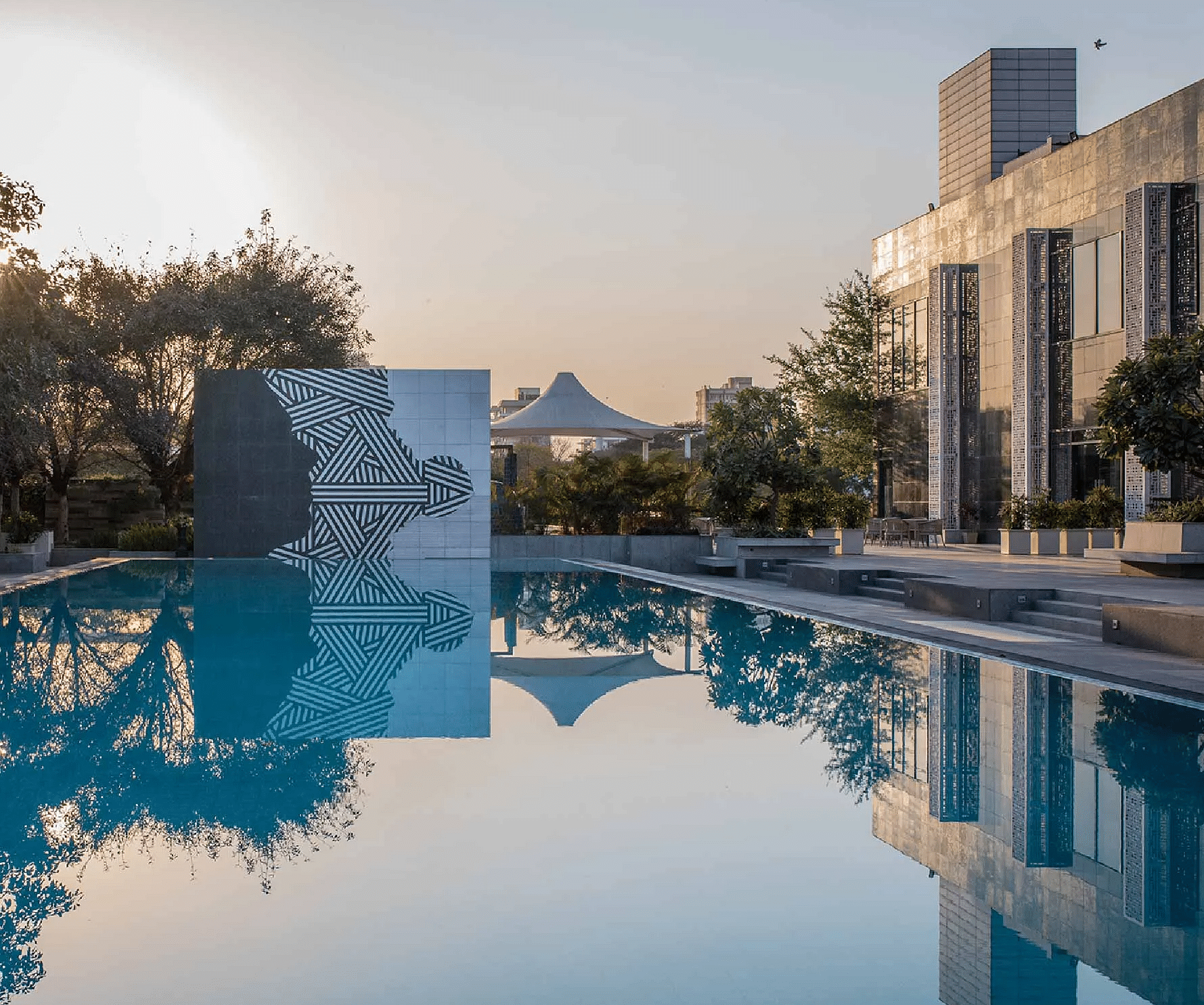 Swimming pool with surrounding buildings and trees at Karma Chalets.