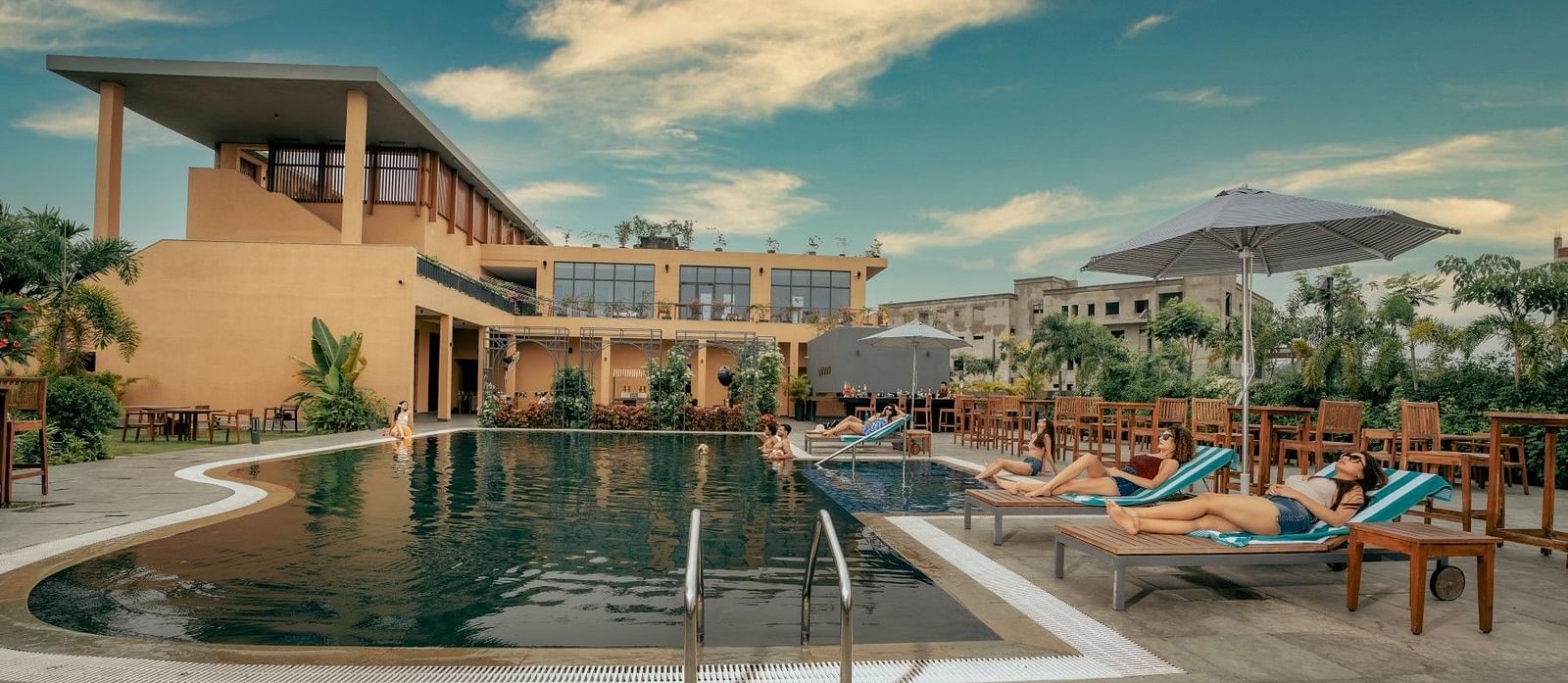 Outdoor swimming pool at at Singalila Club with lounging chairs placed along the periphery