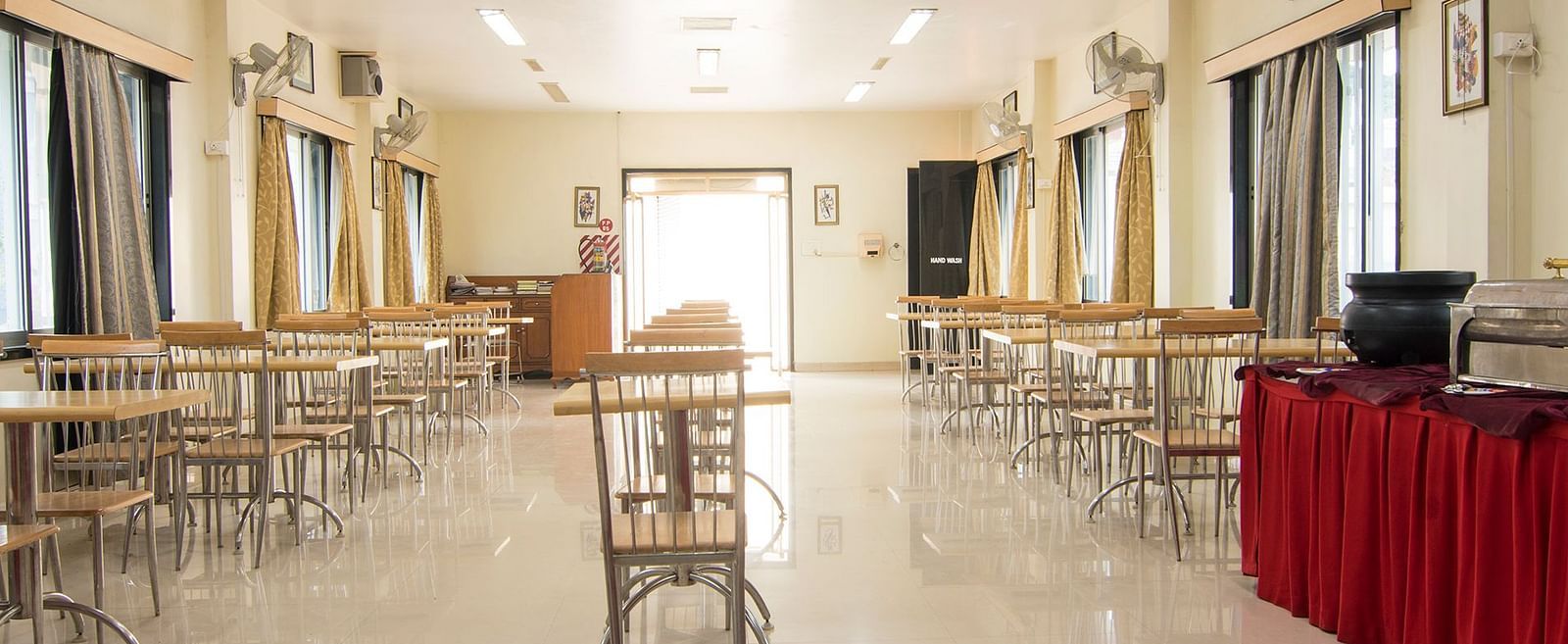 The first conference room image, depicting the arranged seating and podium with a red cloth at Shantiniketan - Budget Stay in Hyderabad near Ramoji Film City.