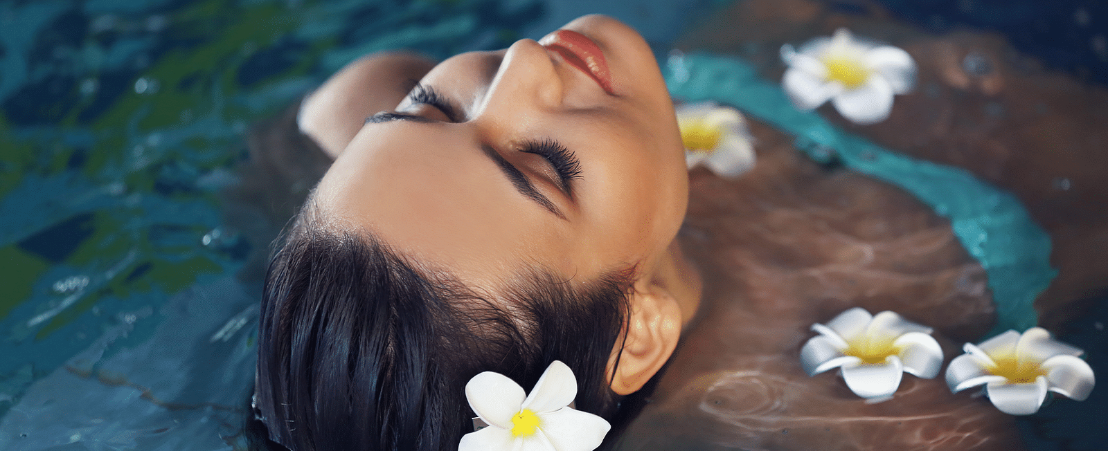 Woman floating serenely in water with flowers, capturing a moment of peacefulness