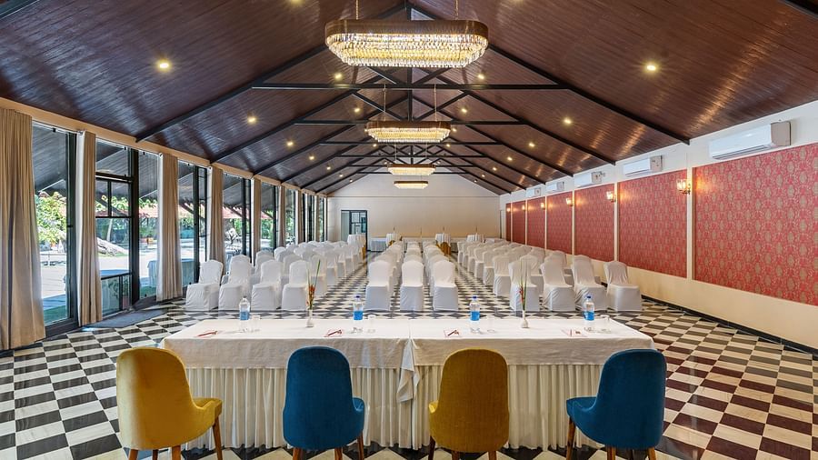 image of the banquet hall streching tot he very end of the room featuring lush green atmosphere from the window  panels in the left at aranya vilas