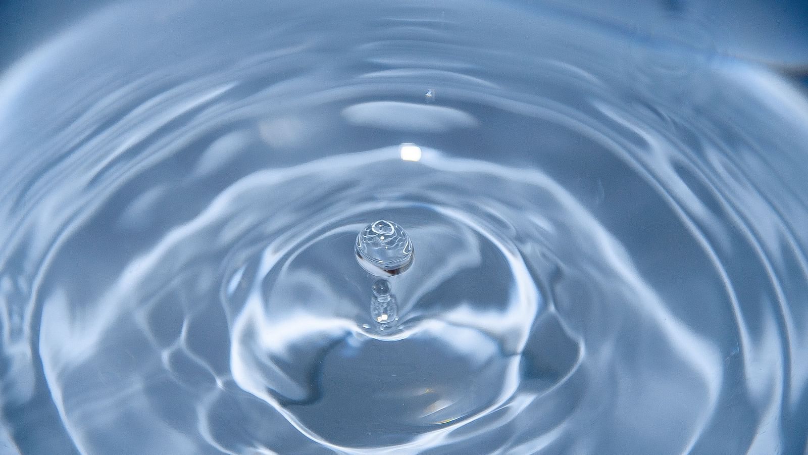 a drop of water hitting a waterbody and causing ripples to it