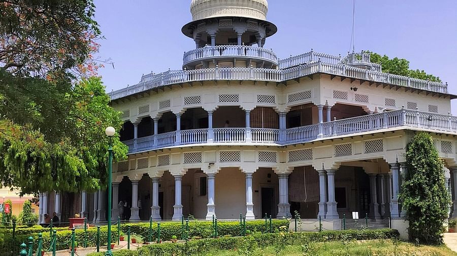 An overview of Anand Bhavan as seen from a distance with a manicured garden in front of it