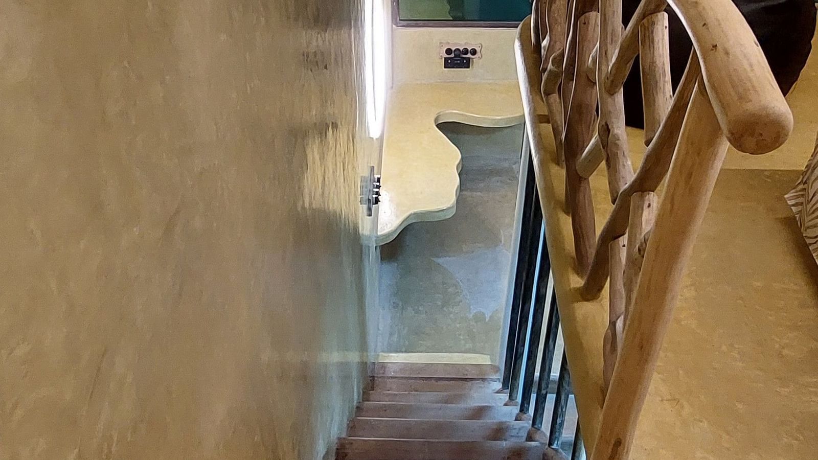 Manta Stairs - with brown walls and stairs with wooden railings.