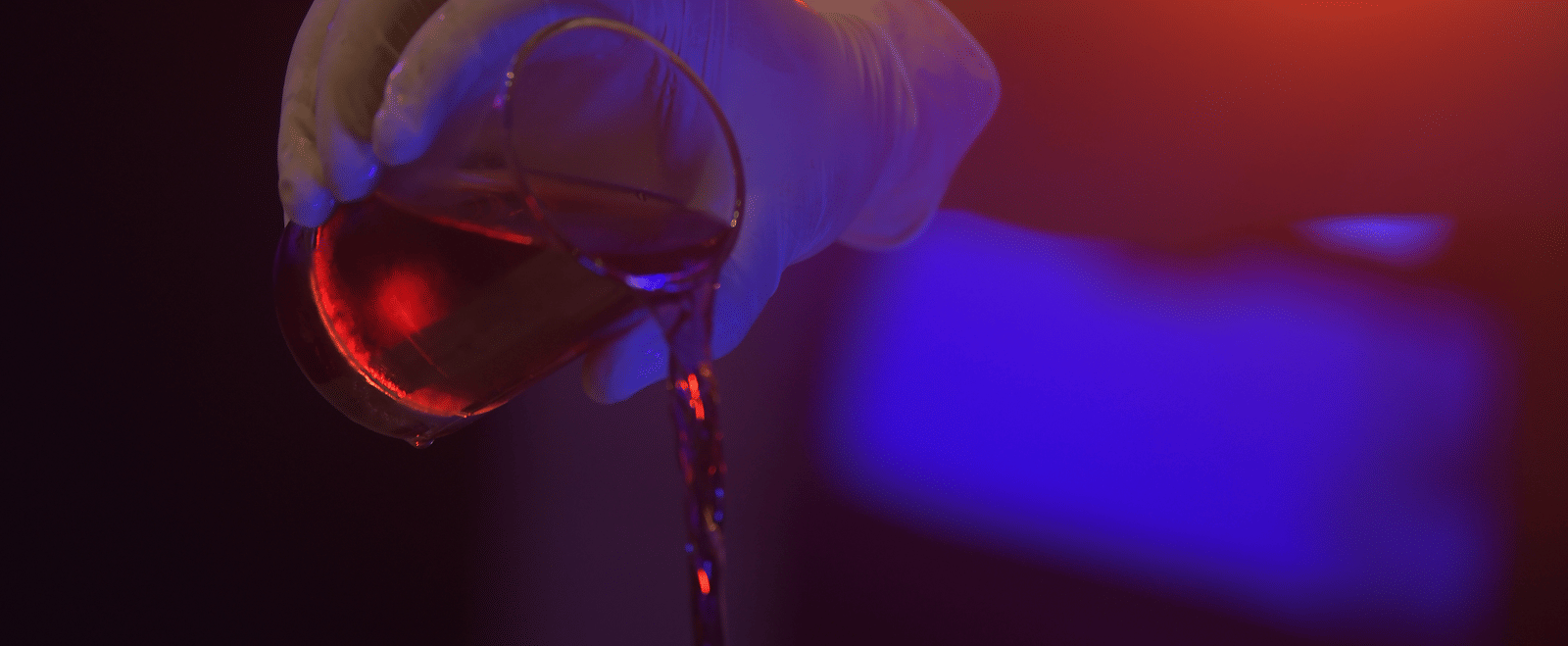 A bartender pouring a drink illuminated by a warm orange light at Hotel Sonar Bangla Mayapur.