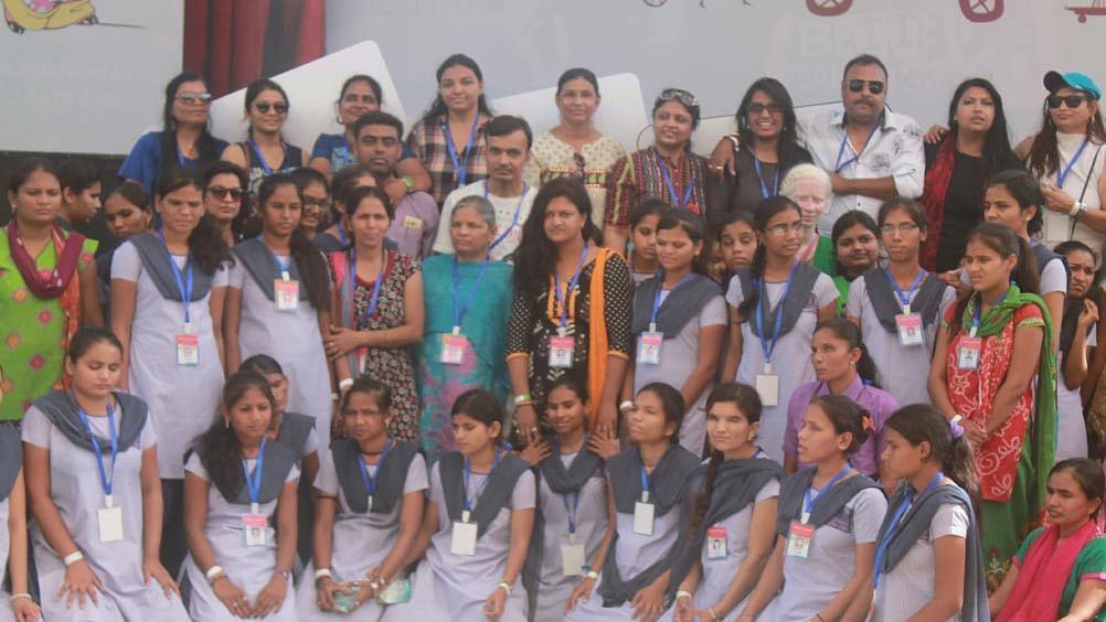 a group of school children in uniform with their teachers posing for the camera