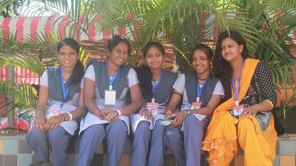 5 children and their teacher sitting and posing for the camera