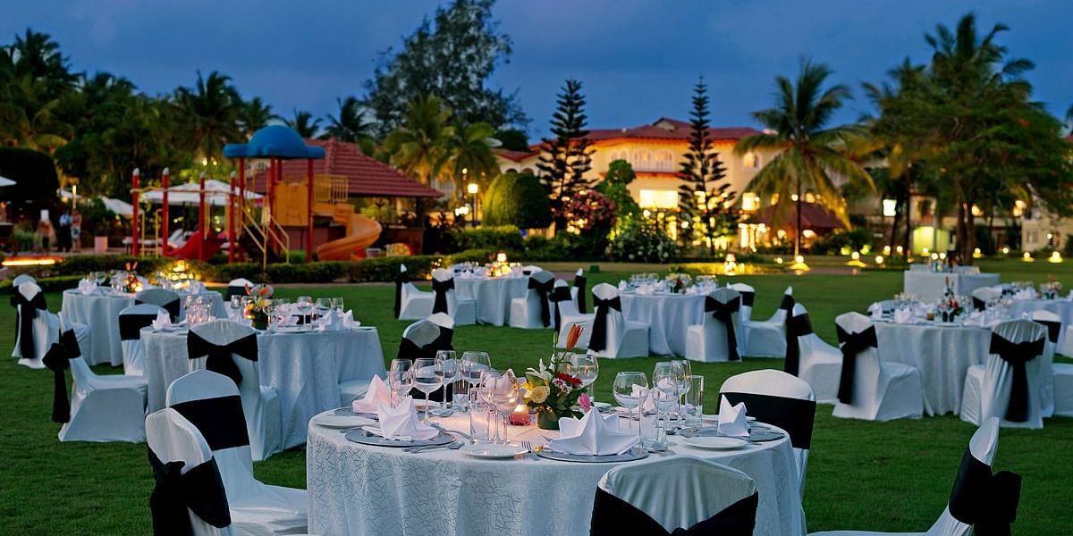 An image of Eden lawns where there are several dining arrangements placed outside on the lawn under the evening sky