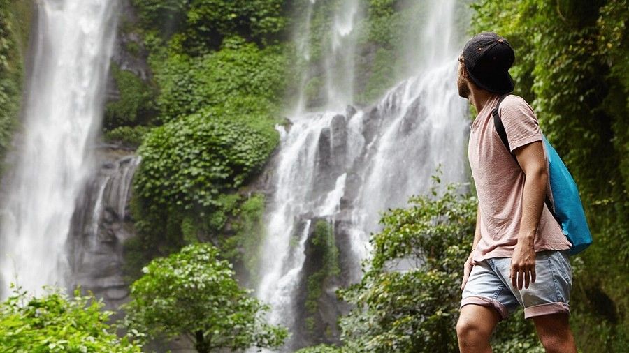 An image of a man looking at the waterfall 