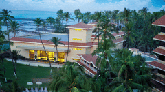 The facade of The Retreat Hotel and Convention Centre, with coconut trees and a pool area in the foreground.
