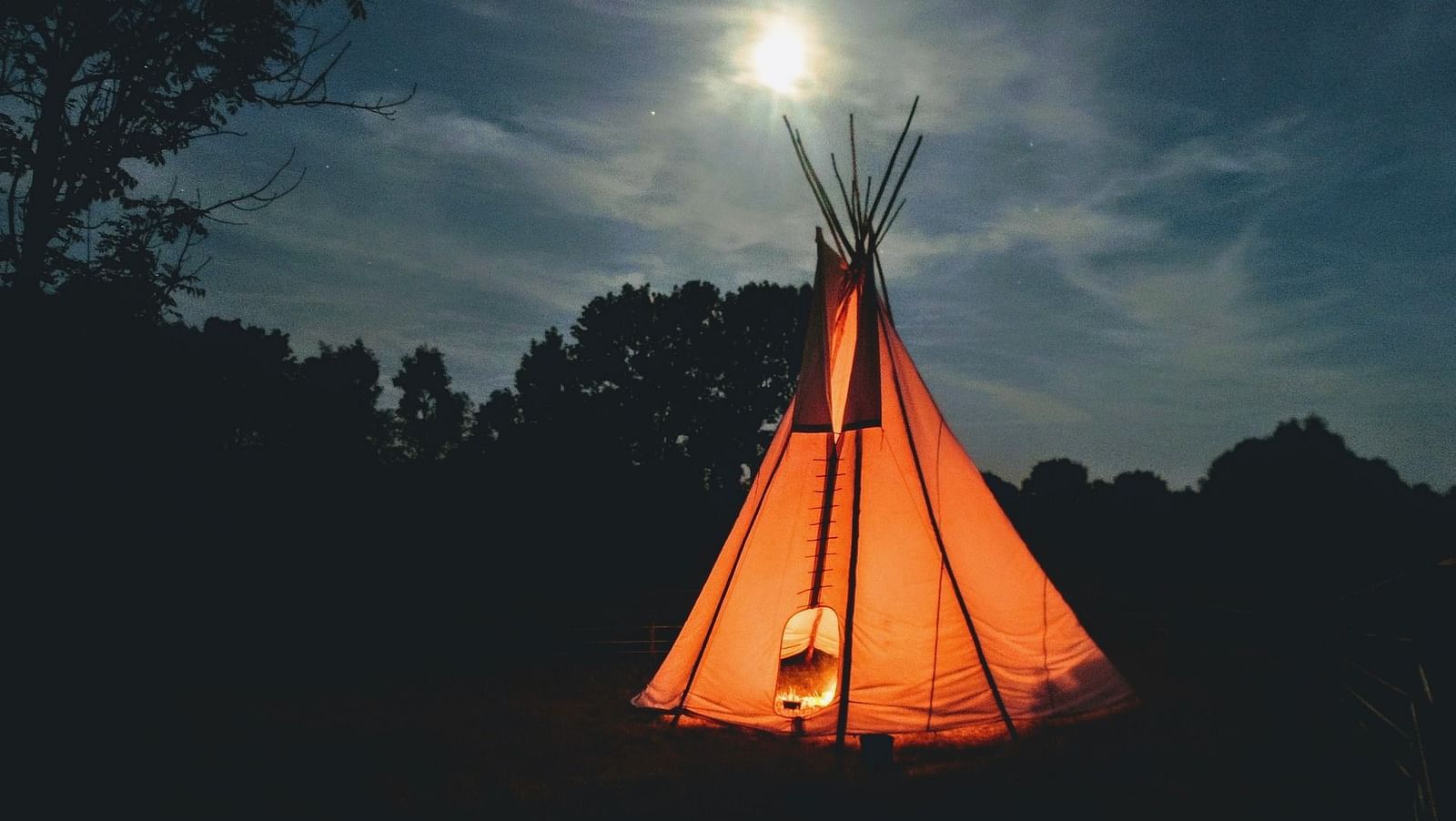 an image of a well-lit tent on the garden at night