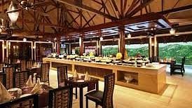 The interiors of Oasis, our multi-cuisine restaurant in Pushkar with tables and chairs and a buffet table 