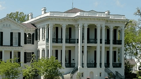 A historic colonial mansion with white pillars and a manicured lawn - S Hotel Kingston, Jamaica