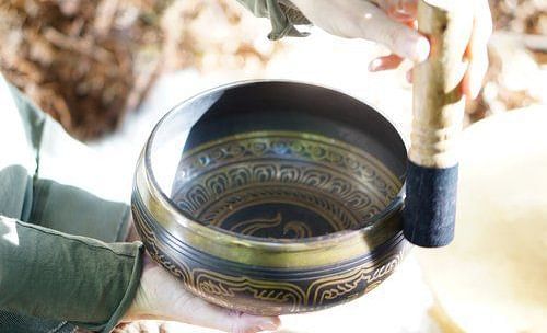 A detailed shot of a person performing sound healing using a Tibetan bowl - Brewery Gulch Inn & Spa