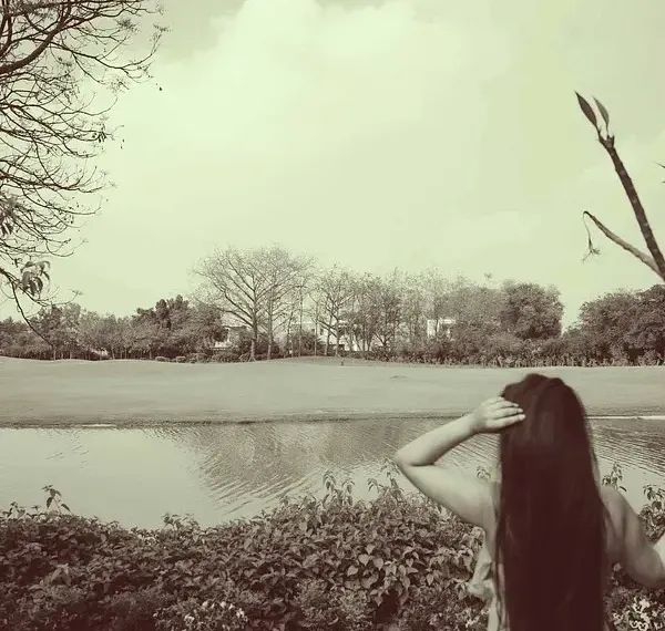 Sepia-toned photo of a person standing by a water body at Karma Chalets.