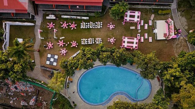 alt-text Bird's-eye view of a wedding venue with a pool and outdoor seating.