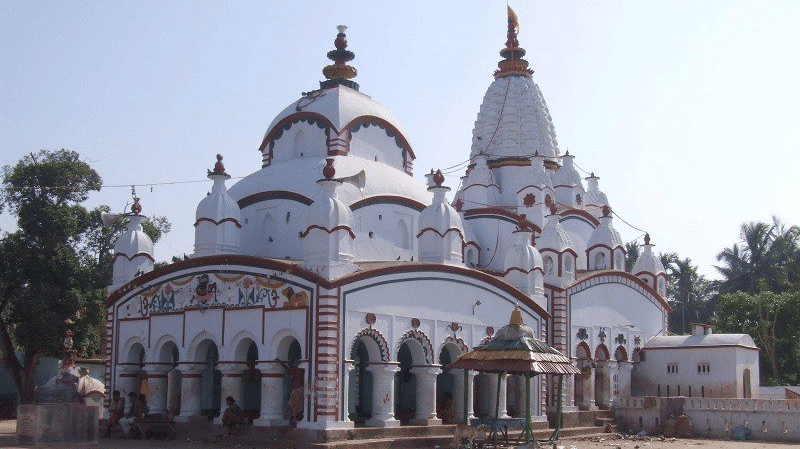 Exterior view of Chandaneshwar Temple featuring traditional Hindu temple architecture with domes, arches, and an open courtyard area for visitors.