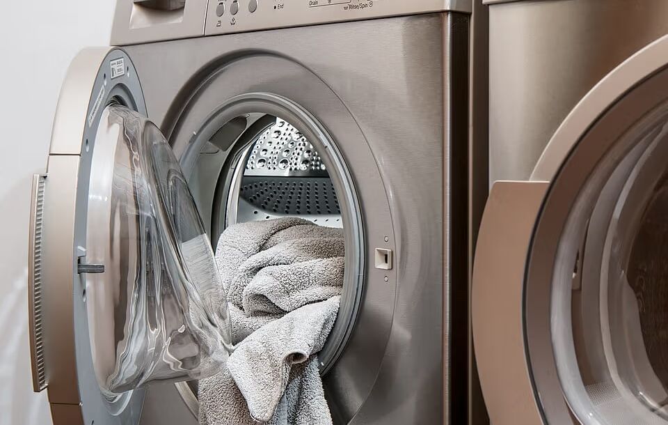 A close-up of laundry inside a washing machine, indicating a laundry service or facility.