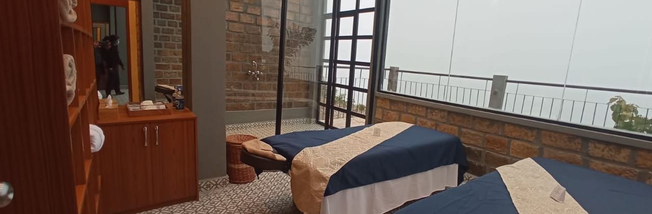 Spa room with massage beds and glass windows at Polo Resort Cherrapunjee.