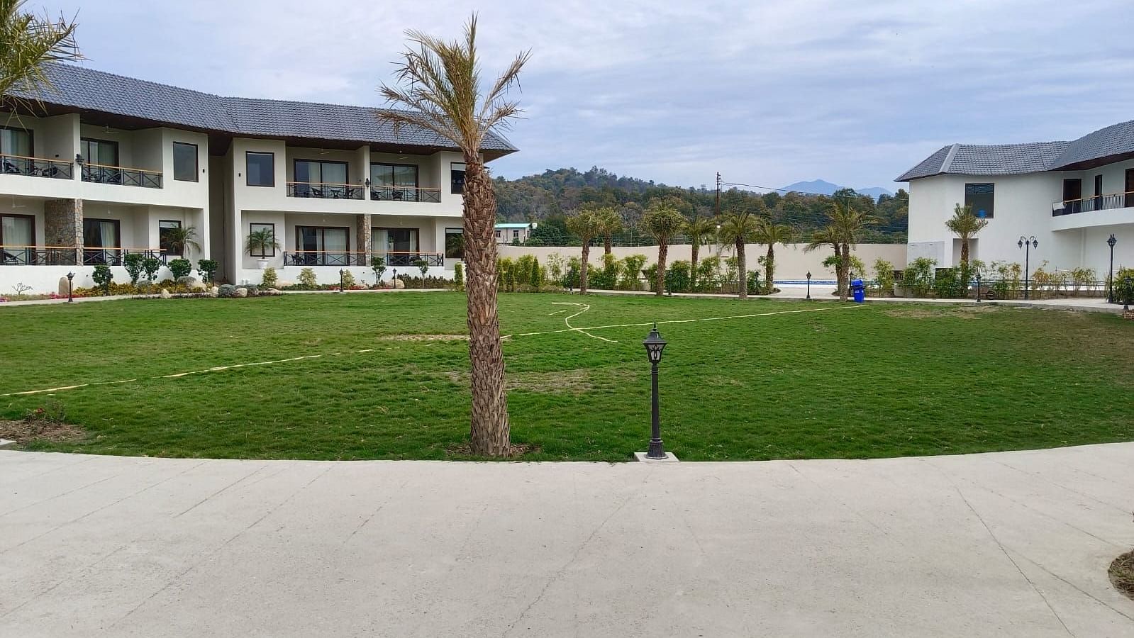 Well-manicured lawn in front of a resort with two-story buildings and balconies - Pebbles & Pines, Corbett