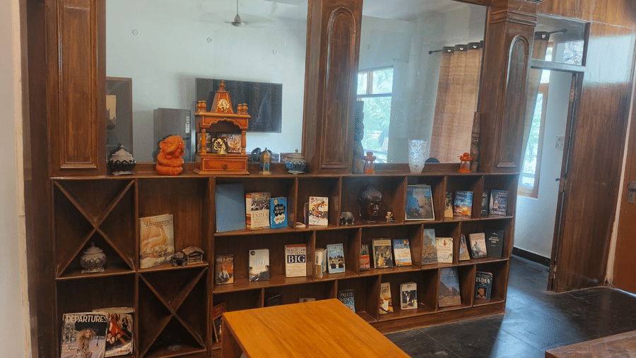 Lounge area with a wooden  book shelf and mini mandir on it. 