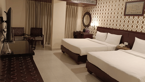 Premium twin bed room with modern interiors and seating area at Pride Ananya Resort Puri