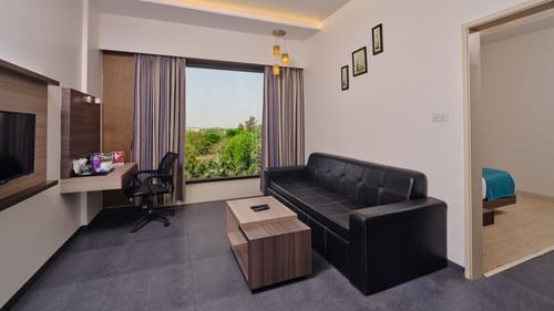 Pride Biznotel Manjusar - a premium bedroom with separate living room and wide window