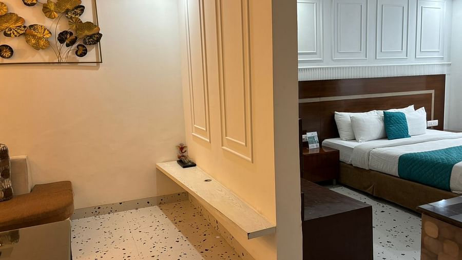 A hotel room with bed, seating area, and decorative wall art - Asian Suites IFFCO Chowk Metro Station, Gurgaon. 