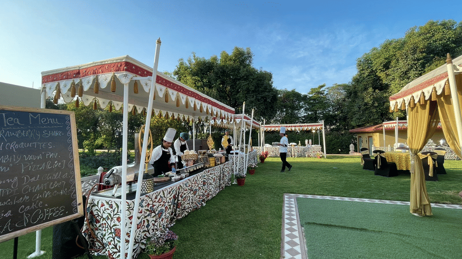 Outdoor event setup with white tents and seating on a green lawn at Heritage Village Resorts & Spa, Manesar.