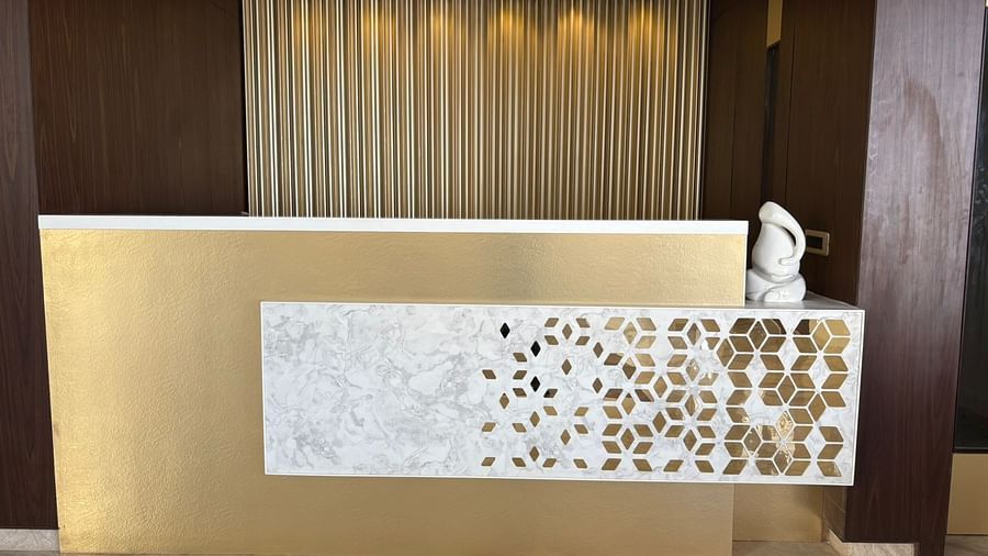 A reception desk with decorative panel and a towel swan at Pride Resort, Jodhpur, showcasing elegant design.