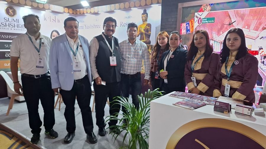 A group of representatives from Sumi Yashshree Hotels & Resorts standing together at their vibrant exhibition booth, showcasing their team spirit. 