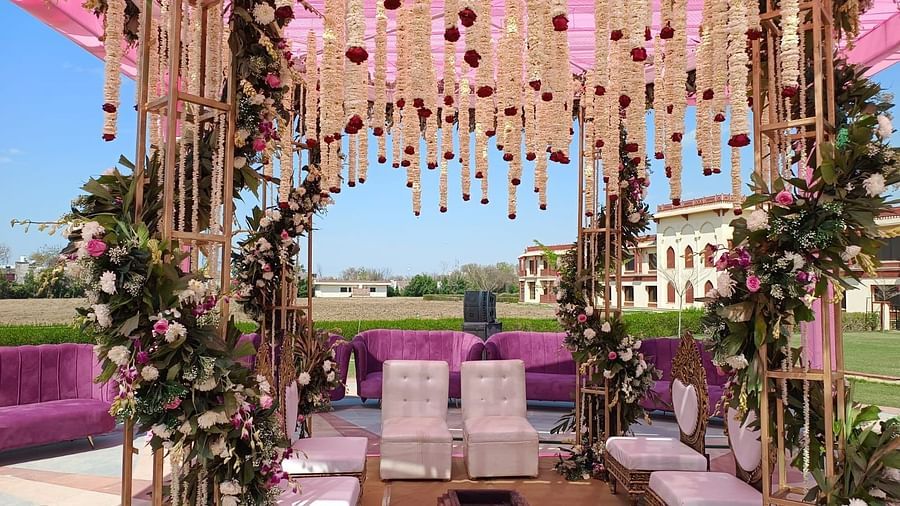 A beautifully decorated mandap at The Ummed Jodhpur, with floral arrangements, chairs, and a view of the surrounding landscape.