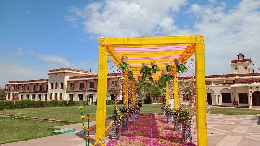 Decorated entrance to The Ummed Jodhpur, with a colorful canopy, flower arrangements, and a view of the palace in the background.