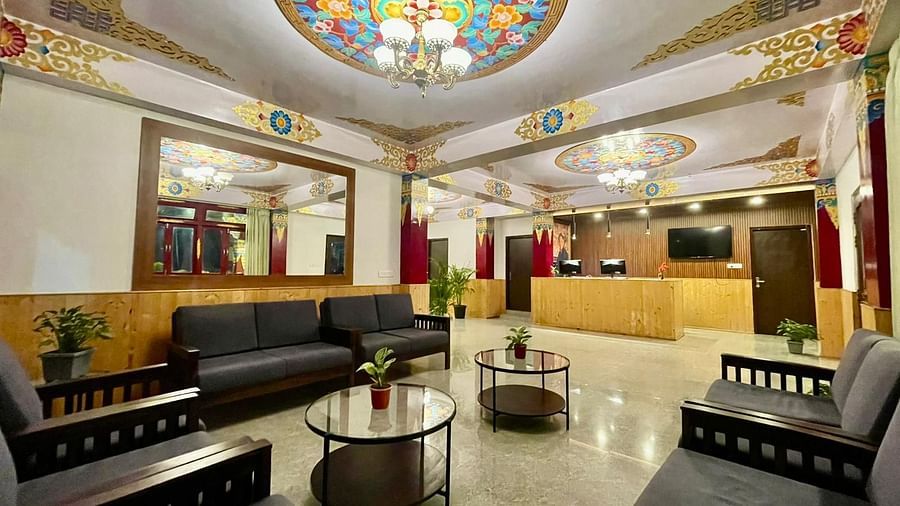 Sofas arranged around two teapoys in the lobby area that has vibrant wall decor | Voyage The Royal Retreat, Gangtok