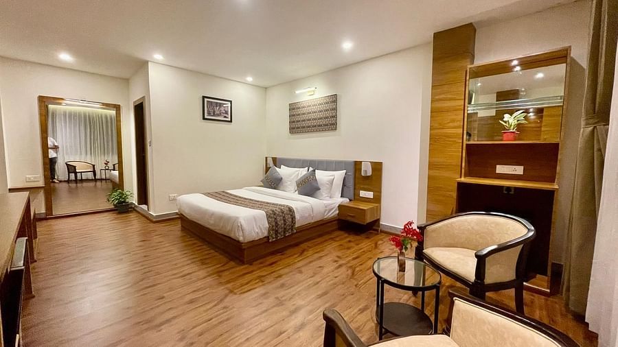 A full view of a room that has a bed, two chairs, and a glass teapoy | Voyage The Royal Retreat, Gangtok