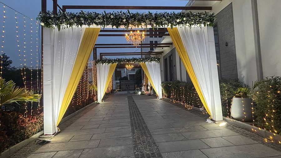 Wedding entrance with a floral archway and white drapes.