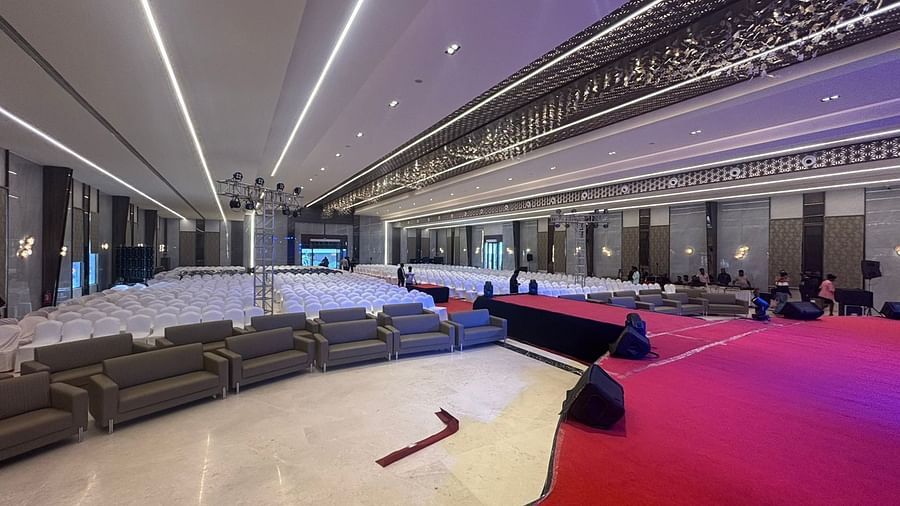 Banquet hall with a stage, seating area, and decorative lighting.