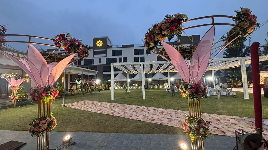 Outdoor wedding venue with a raised stage, lawn, and lighting.