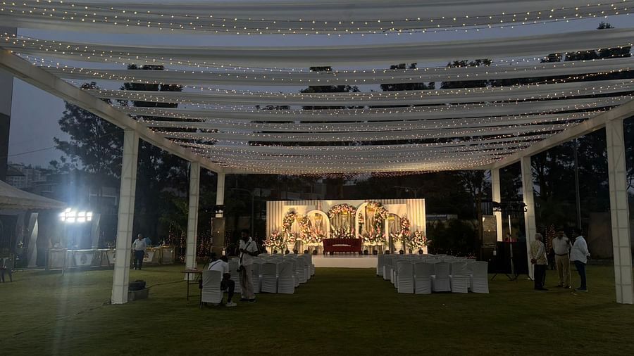 Outdoor wedding ceremony with a flower aisle and white chairs facing the stage.