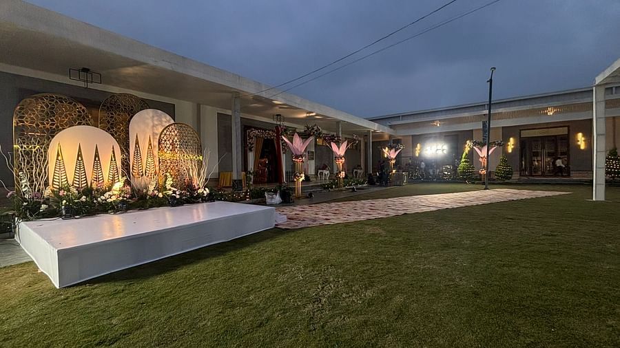 Outdoor wedding stage with a floral backdrop and a raised platform.