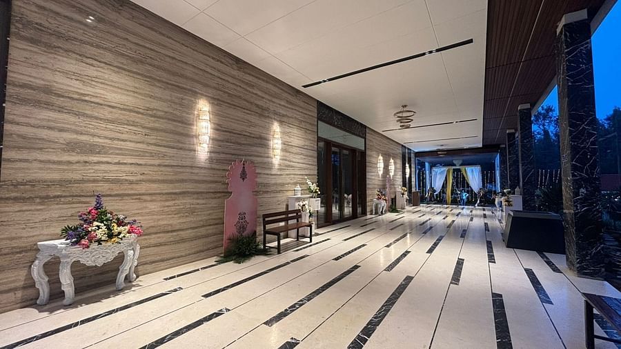 Indoor reception hall with a wooden wall, white floor, and a bar area.