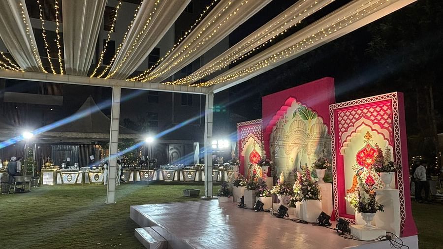 Outdoor stage area with ornate decorations, floral designs, and seating arrangements for an evening event.