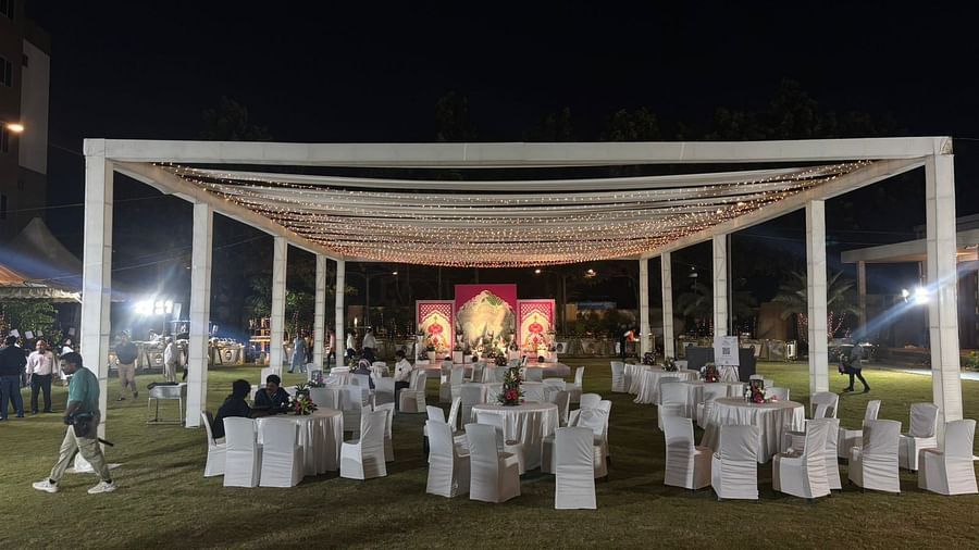 Evening outdoor seating arrangement under a white canopy with dining tables and chairs neatly organised.