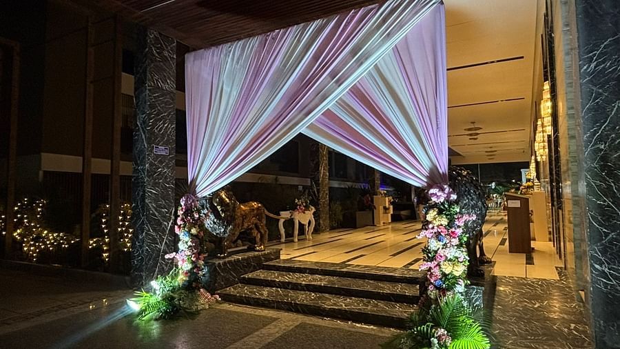 Close-up of a grand entrance with draped fabric, floral arrangements, and decorative lighting.