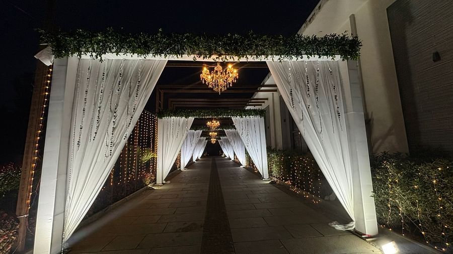 Illuminated entrance pathway lined with drapes and  featuring a chandelier.