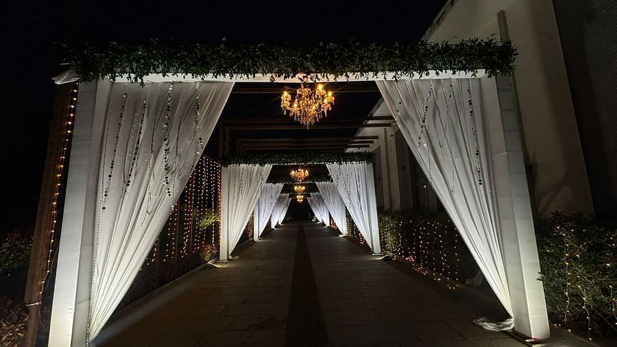 Illuminated entrance pathway lined with drapes and  featuring a chandelier.