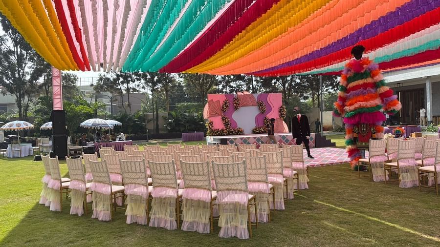 An image of a lawn decorated with  colourful fabrics, flowers, designed carpets, chairs,and other decorative items to organise an event - VRR Astoria Hotel and Convention Centre