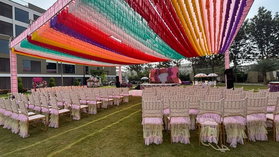An image of a lawn decorated with  colourful fabrics, flowers, designed carpets, chairs,and other decorative items to organise an event - VRR Astoria Hotel and Convention Centre