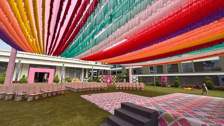 An image of a lawn decorated with  colourful fabrics, flowers, designed carpets, chairs,and other decorative items to organise an event - VRR Astoria Hotel and Convention Centre